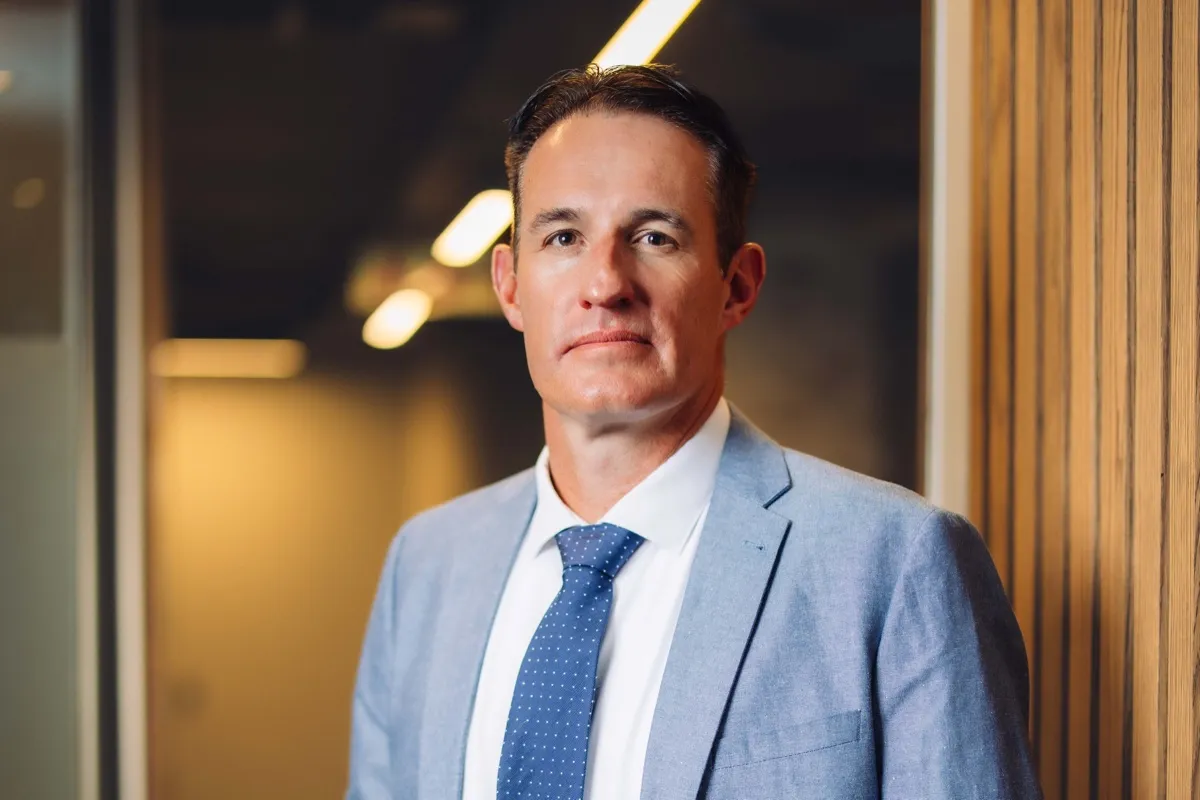 Stephan Potgieter, CEO of BetterHome Group Mortgage Origination and BetterBond, in a light blue jacket and blue tie, standing in an office corridor
