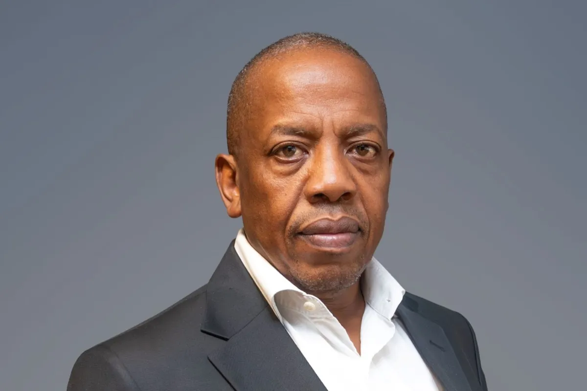 Malose Kekana, CEO of Pareto Group, in a dark suit jacket and open-necked white shirt against a grey background