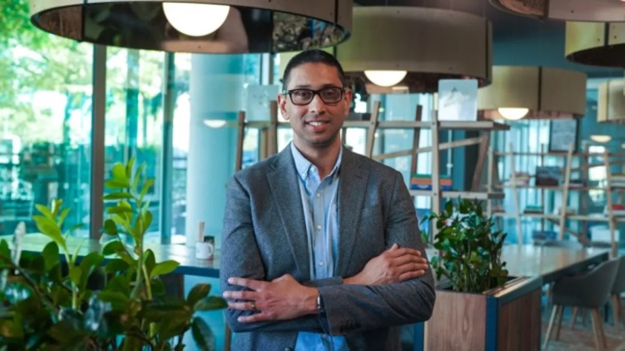 Desigan Chetty, Chief Operating Officer of Property Point, in a grey blazer with his arms crossed in a bright café