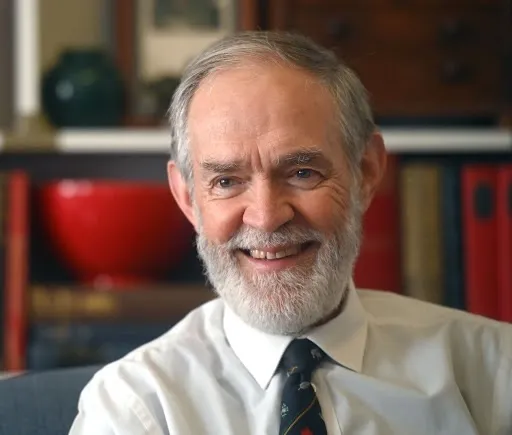 Dr Roelof Botha, Economic Advisor to BetterBond Home Loans, smiling, with white hair and beard, in a white shirt and patterned tie