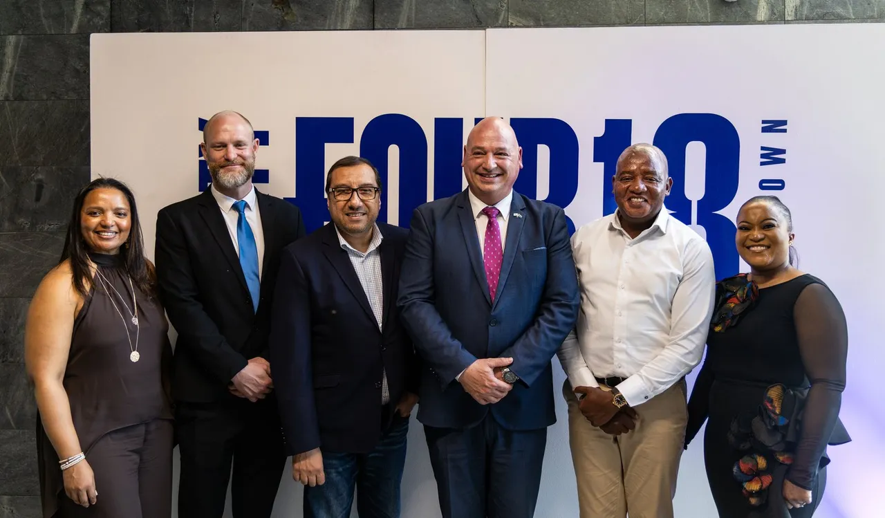 Six guests stand in front of a large blue ThirtyFour18 logo at the launch