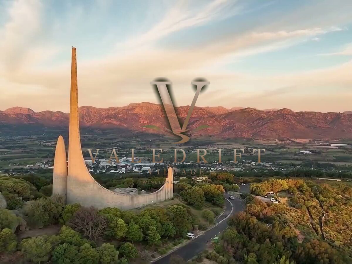 The Valedrift Village logo over the Taal Monument and the Paarl Winelands at sunset